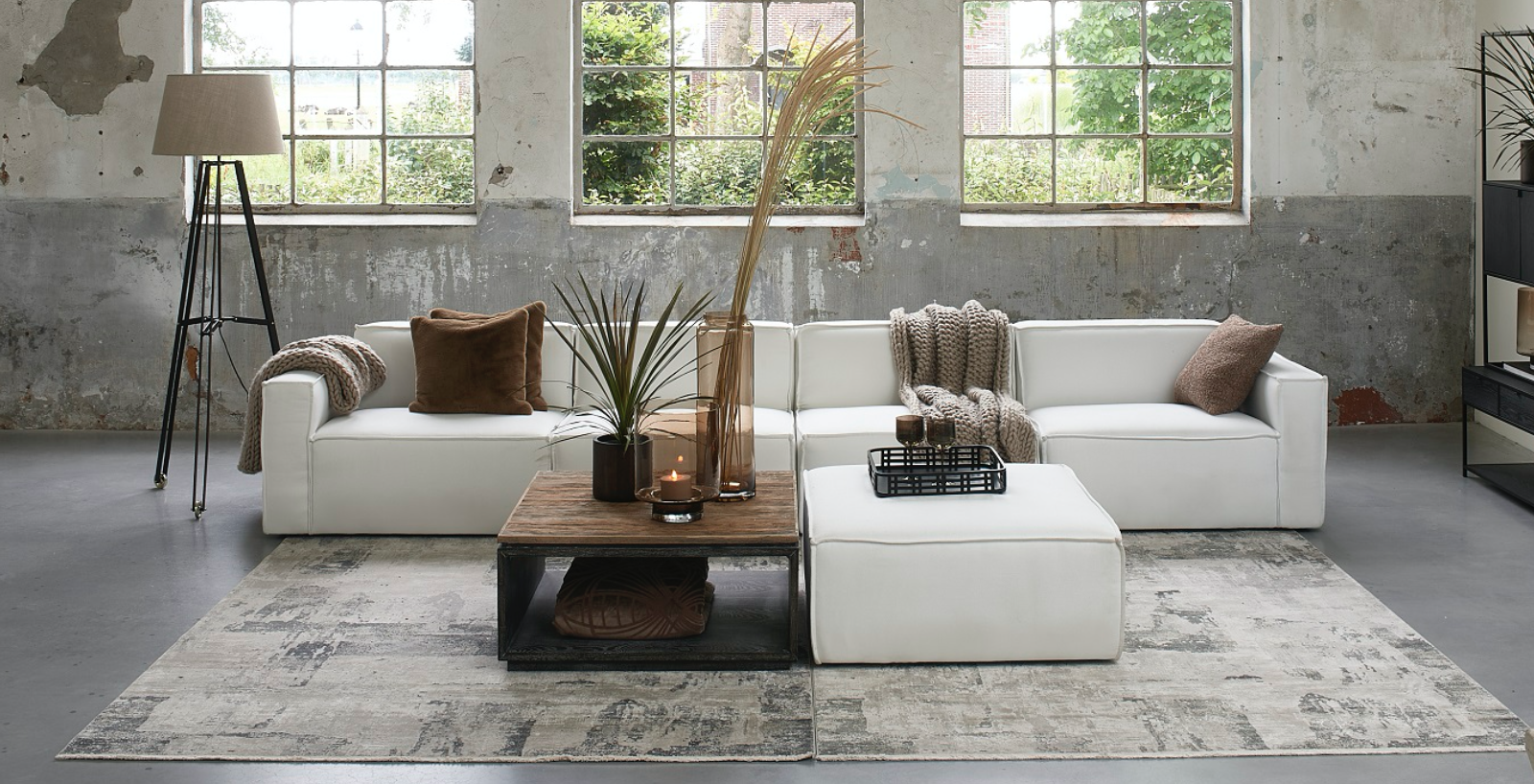 Rivièra Maison elegante Wohnzimmereinrichtung mit Sofa, Coffetable, Lampen und Teppich.