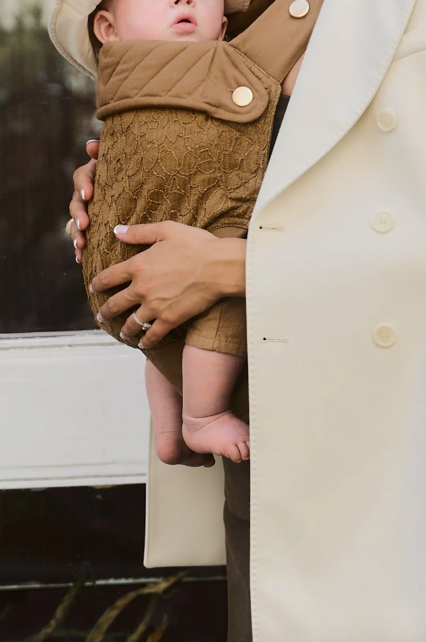 Braune Babytrage MIO von KAS Kopenhagen mit gekreuzten Schultergurten
