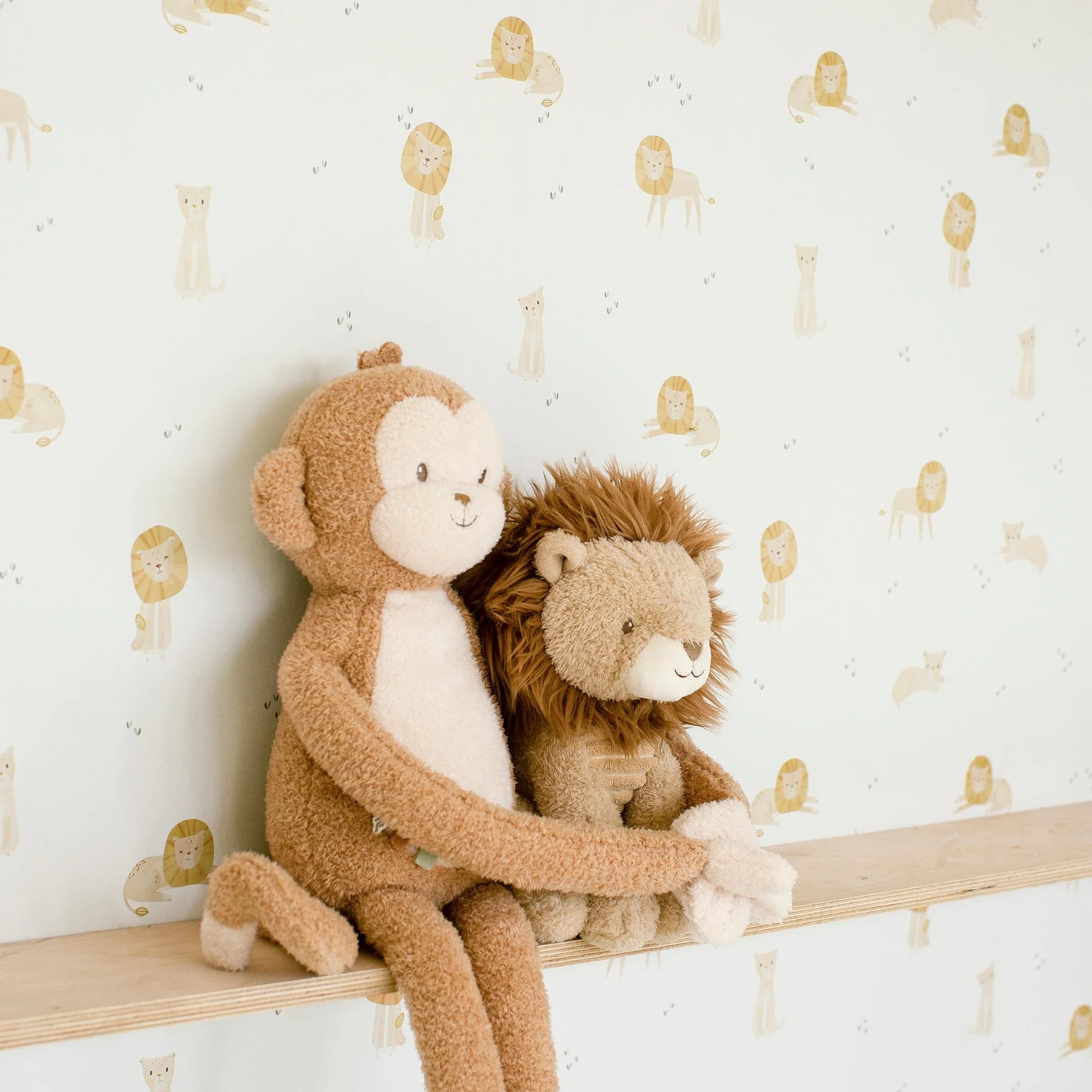 Grosser Kuschelaffe von Little Dutch in Braun sitzt mit Kuscheltier Löwe im Kinderzimmer