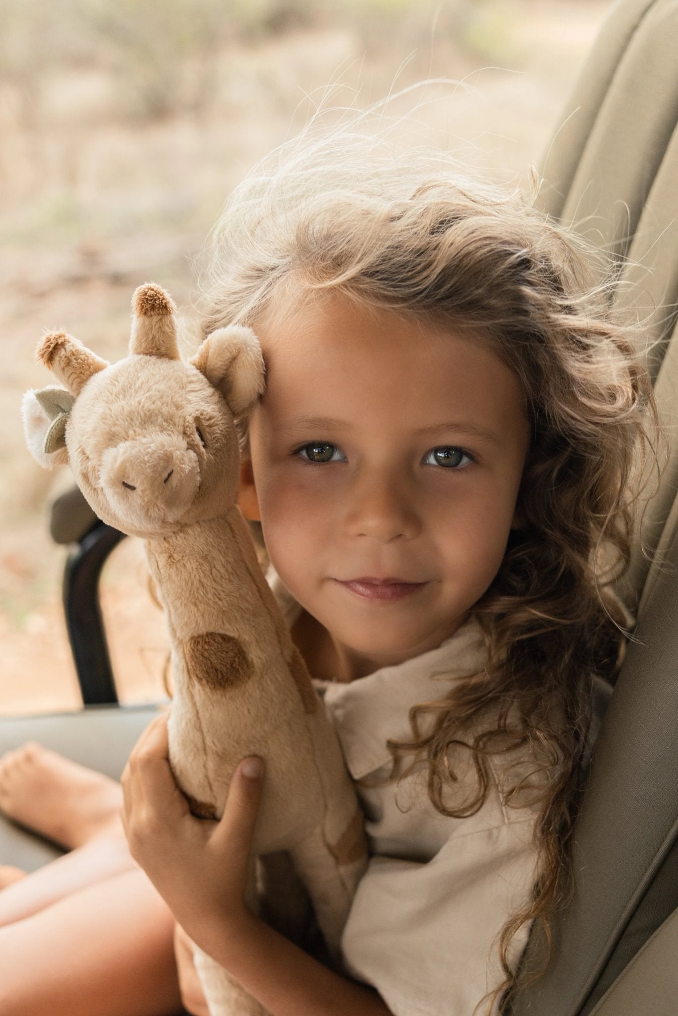 Mädchen mit gelber Giraffe Kuscheltier aus der Safari Friends Kollektion